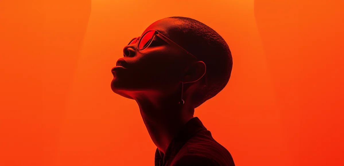 Professional portrait against a bright orange background.